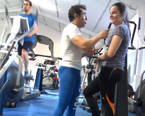 Monitor acompañando a una socia en la zona de cardio