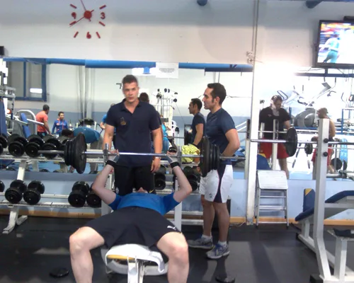 Socios entrenando press de banca en la sala de musculación