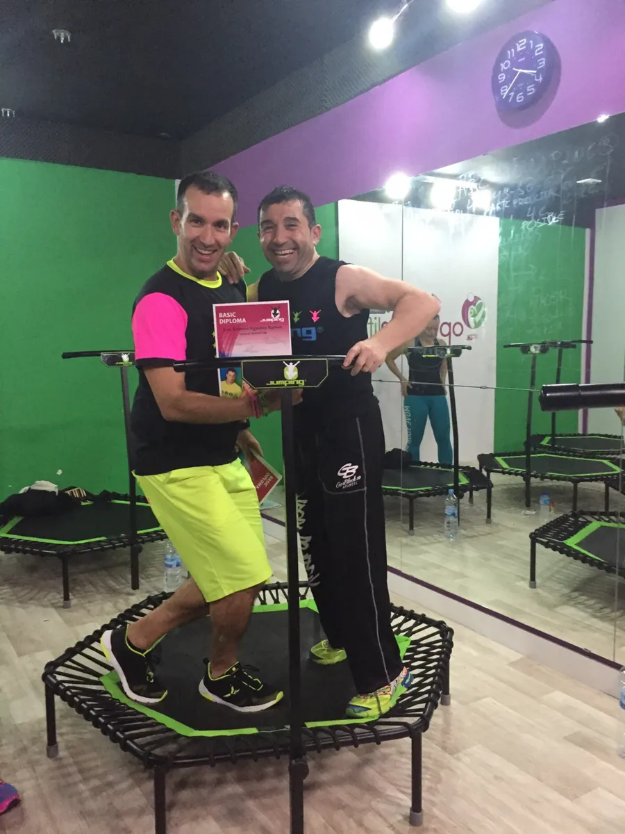 José Antonio Sigüenza Ramón sobre una cama elástica mostrando su diploma de técnico en Jumping