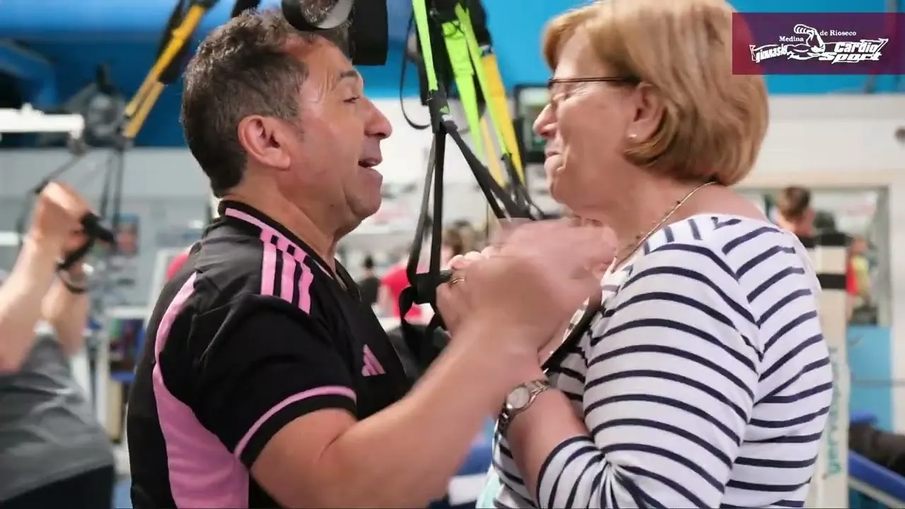 Monitor entrenando con una socia en las cintas de TRX